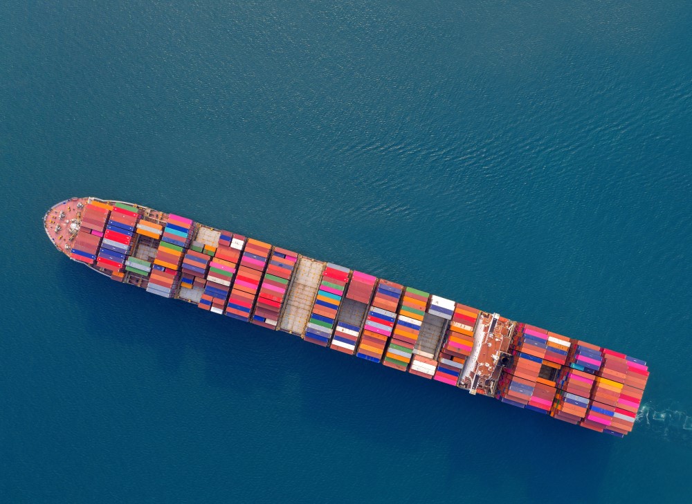 An aerial view of a container ship laden with cargo